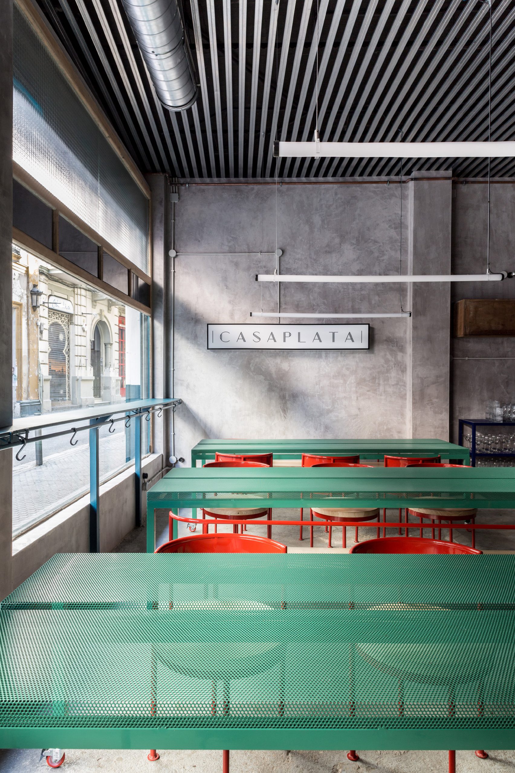 Мебель пастельных тонов контрастирует с бетонными стенами в ресторане «Casaplata» в Севильи